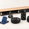 Pack Atelier Bureau — composition complète Étagère de bureau, quatre accessoires Voronoï noirs et support de téléphone pliant bleu sur fond ivoire.
