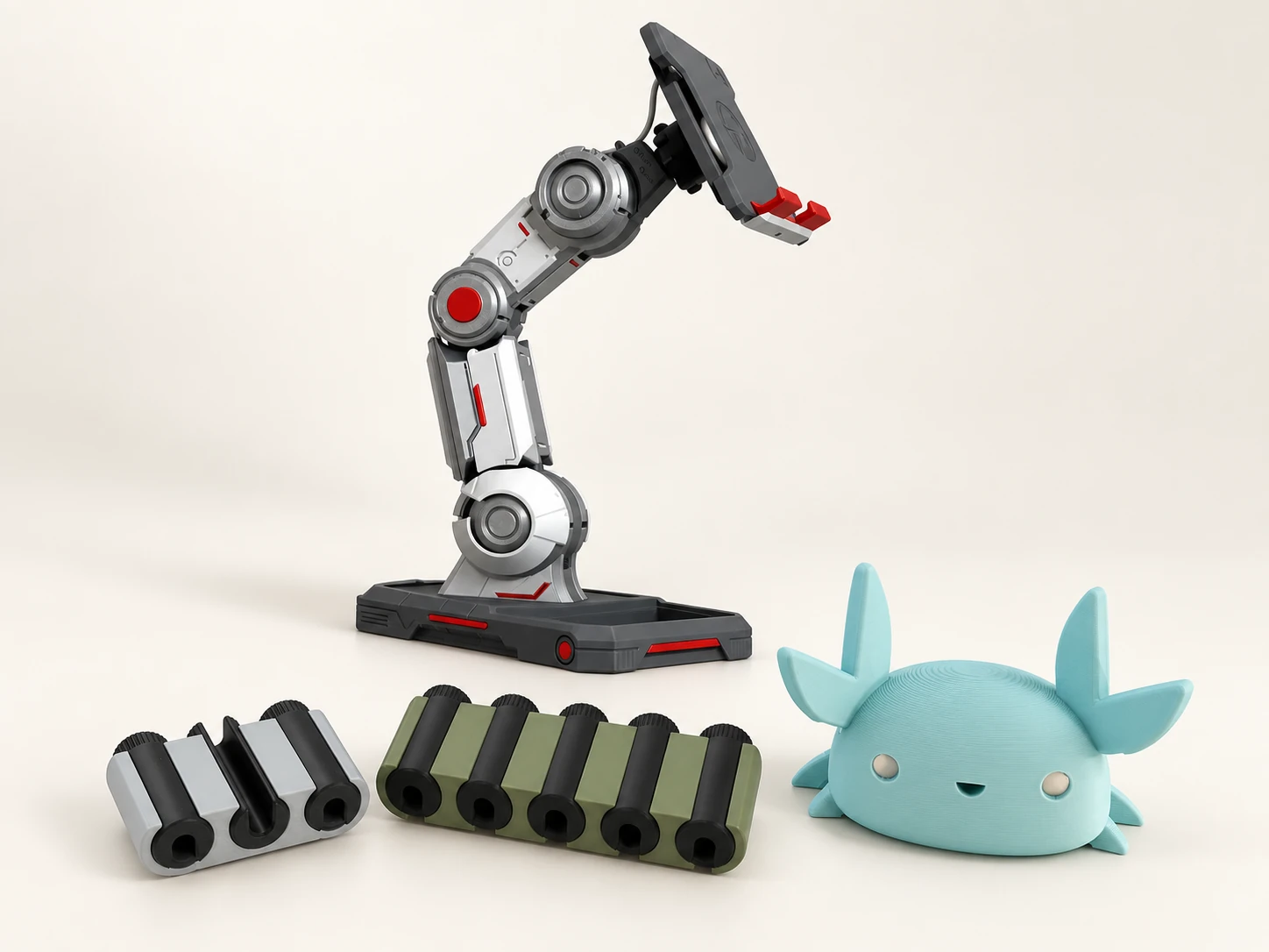 Pack Bureau — composition complète Support de téléphone à bras robotique, crabe porte-stylo turquoise et deux organiseurs de câbles sur fond ivoire.